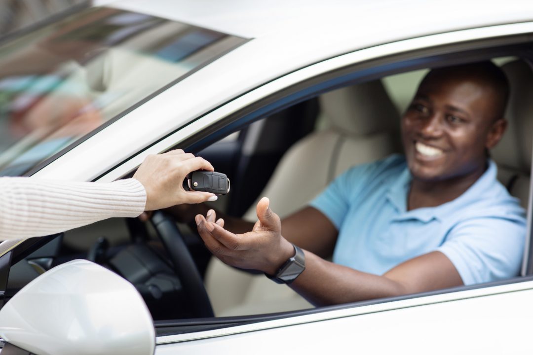 black man taking key from auto renting car for trip.jpg